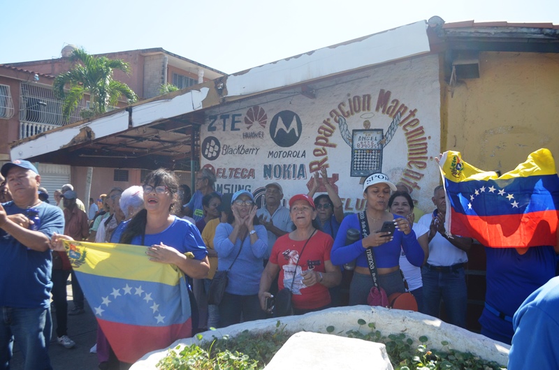 Un grupo de protestantes se reunió allí con pitos, banderas y pancartas gritando consignas