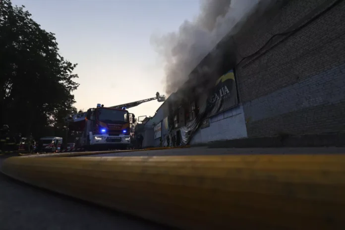 Trabajadores de rescate apagan el incendio de un almacén de ayuda humanitaria destruido por un ataque de drones rusos en Zaporiyia, Ucrania
