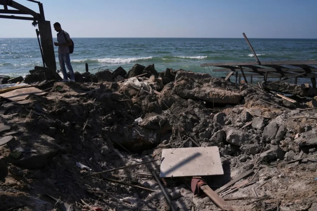 Un palestino inspecciona una zona cercana al café que resultó dañada en un ataque israelí el lunes