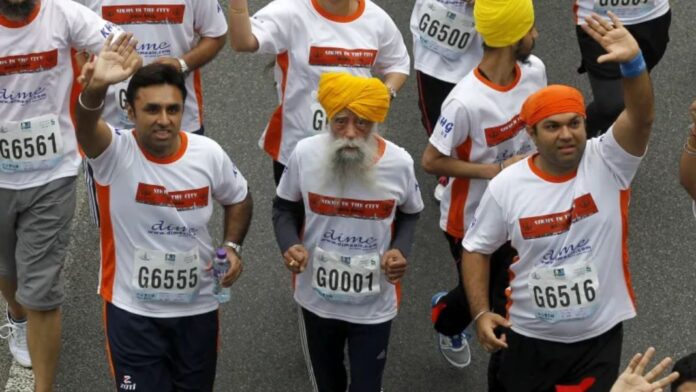 auja Singh, de 101 años (centro), corredor de maratón centenario, originario de Beas Pind, en Jalandhar, India, pero residente en Londres, corre una carrera de 10 kilómetros, parte del Maratón anual de Hong Kong, en Hong Kong el domingo 24 de febrero de 2013
