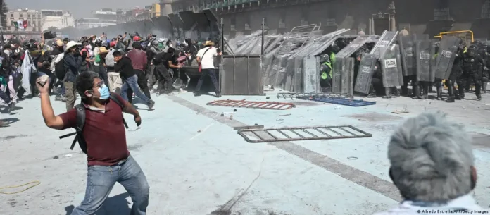 Manifestantes se enfrentan a la policía antidisturbios en Zócalo, Ciudad de México