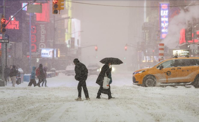 Peatones cruzan Times Square, en Nueva York, en medio de fuertes nevadas